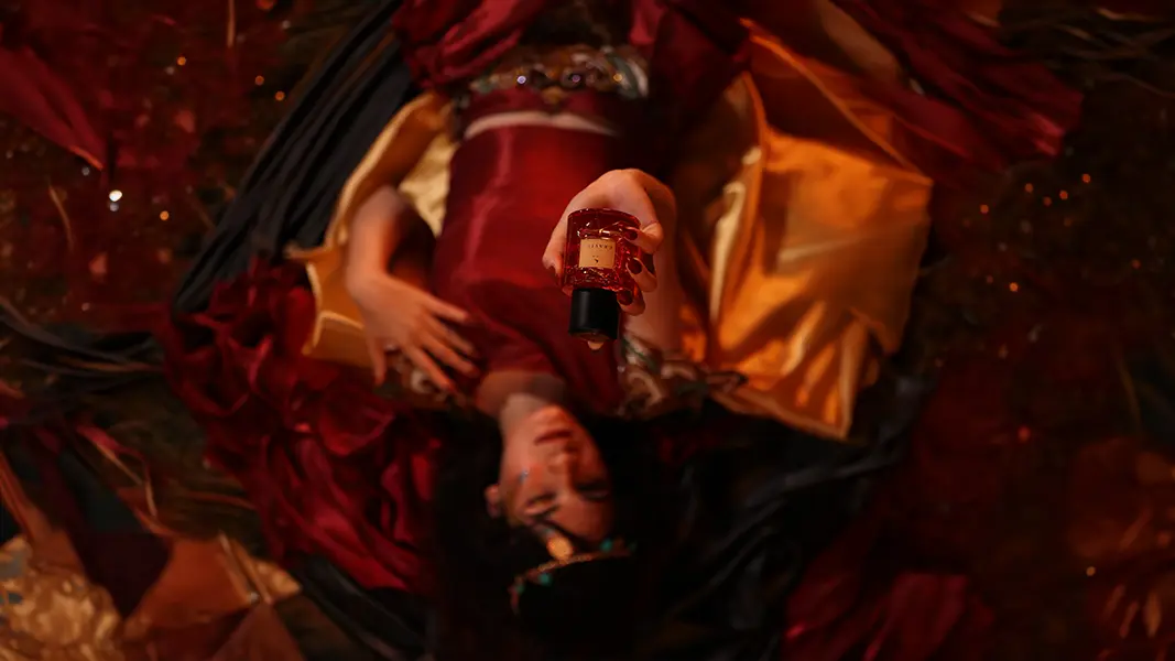 Perfume bottle styled on folds of red and gold silk